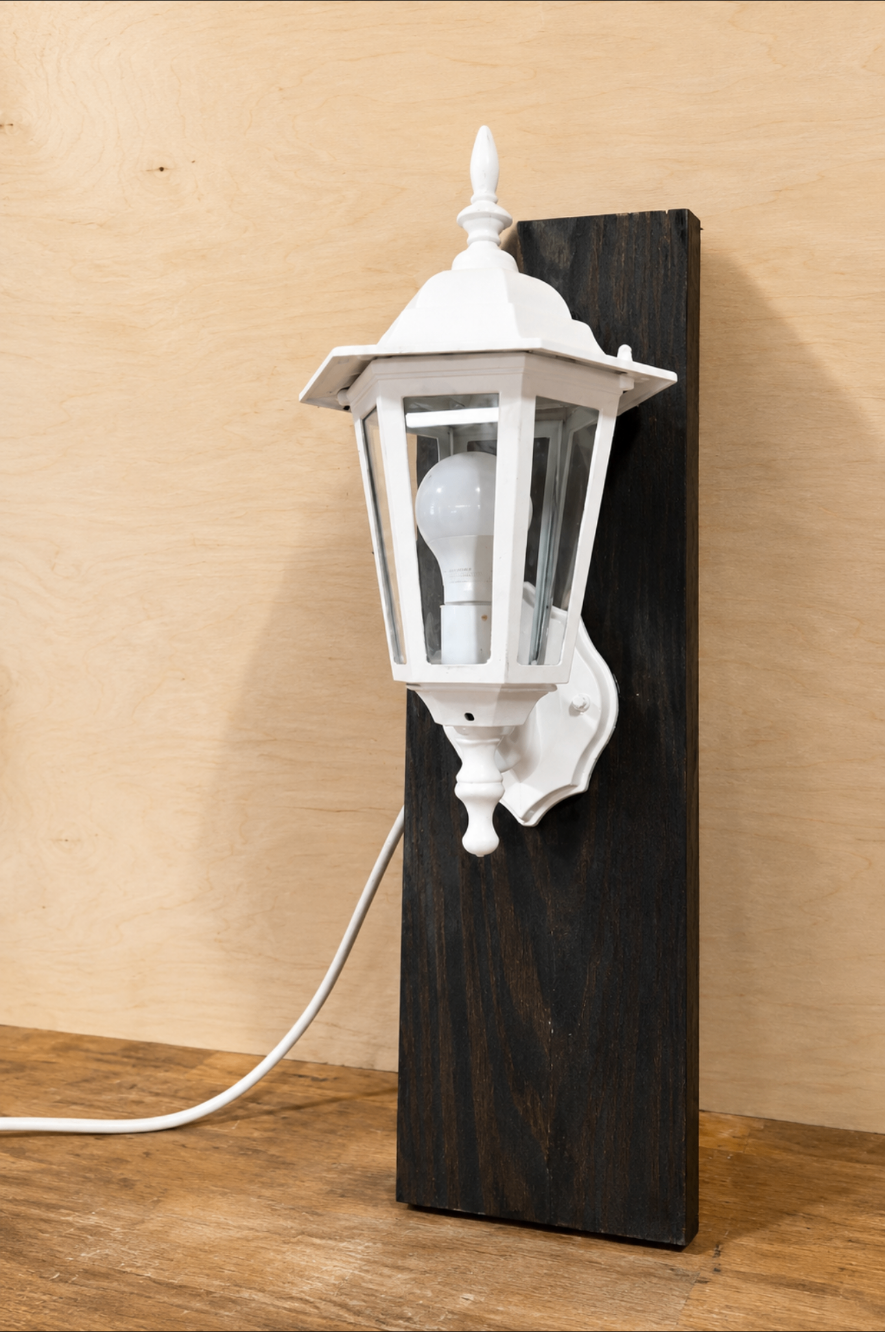White lantern mounted on a dark stained wooden board