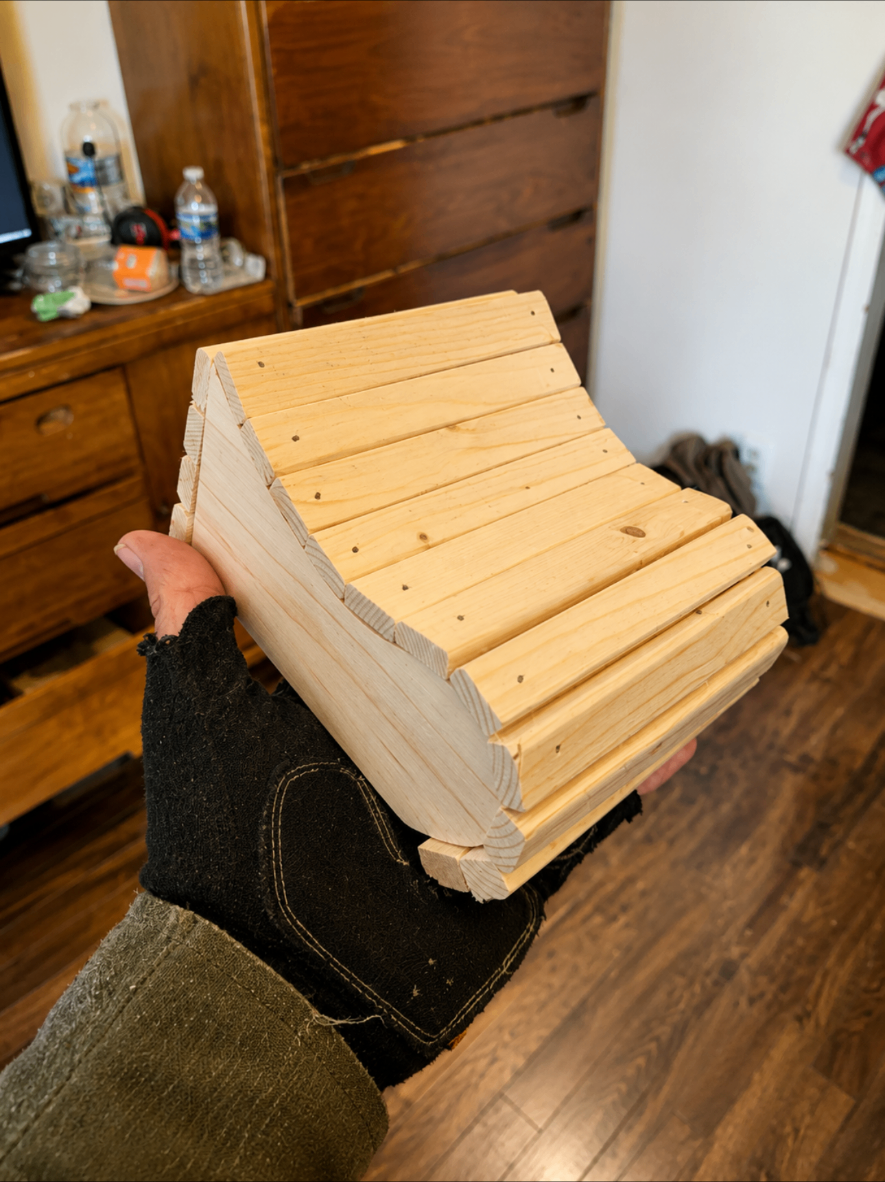 Small unfinished pine slatted chair held by hand